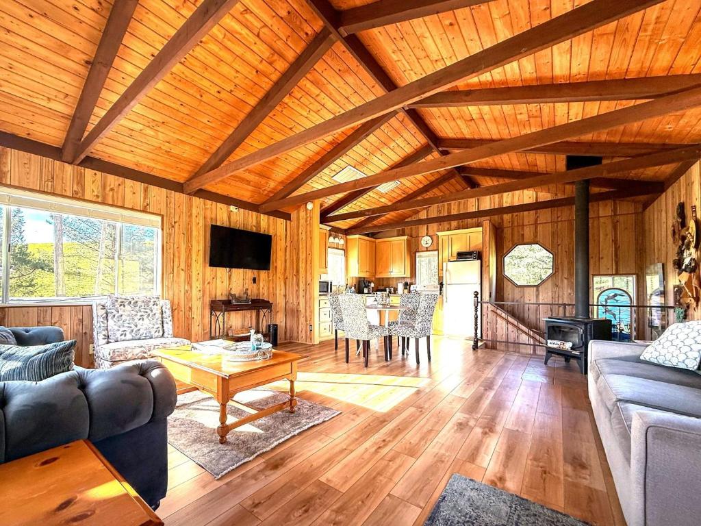 a large living room with wooden ceilings and a table at Cambria Mountain View Retreat in Cambria