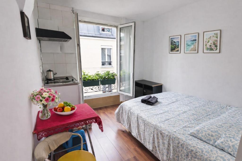 a bedroom with a bed and a table with a bowl of fruit at Studio La Gare in Paris