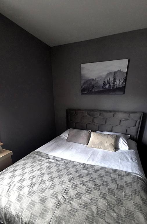 a bedroom with a large bed with white sheets at Mihailo Konaci hotel Andjela in Kopaonik
