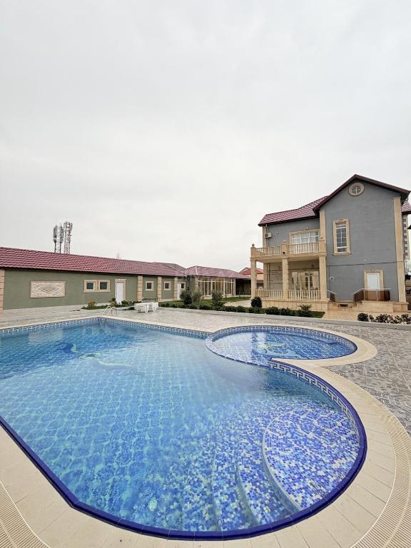 a large swimming pool in front of a house at Novxanı Villa in Baku