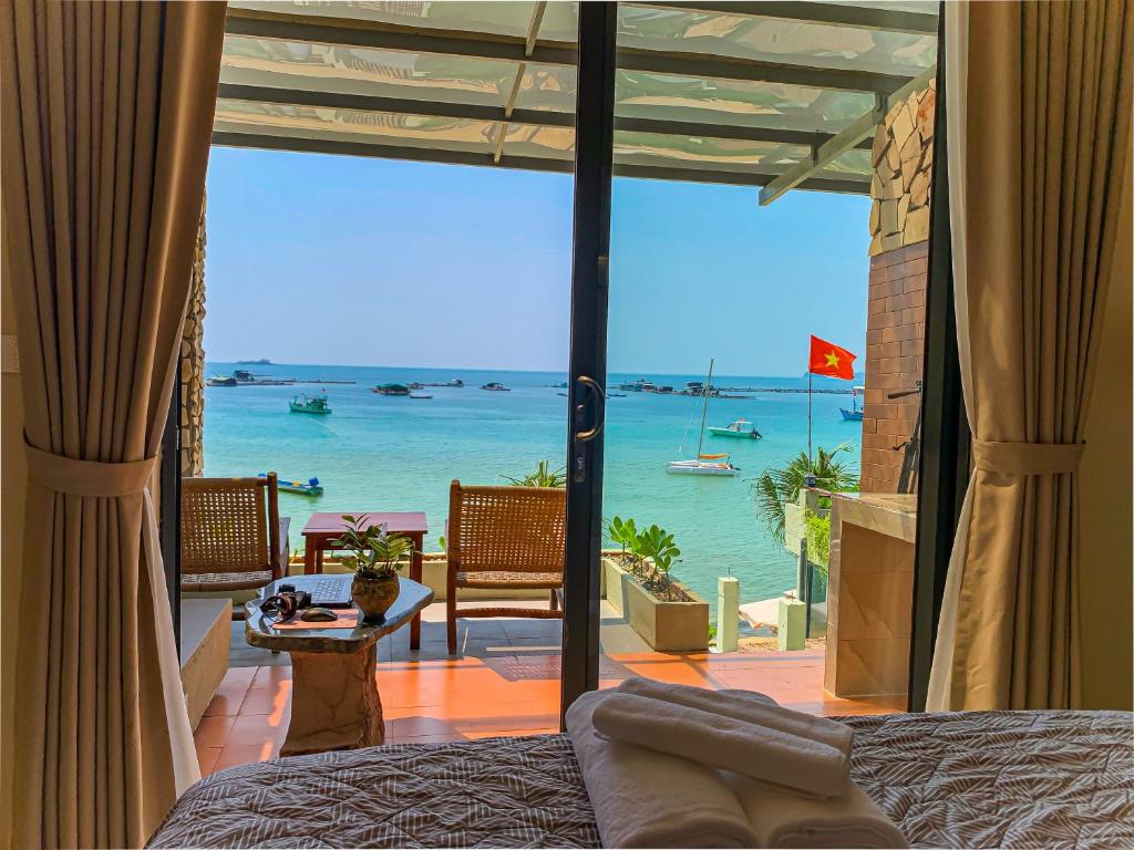 a bedroom with a view of the ocean at Chill Beach House in Phú Quốc