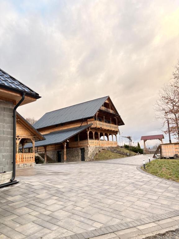 a large wooden building with a gambrel roof at Cabana CORNESTEAN in Sighetu Marmaţiei