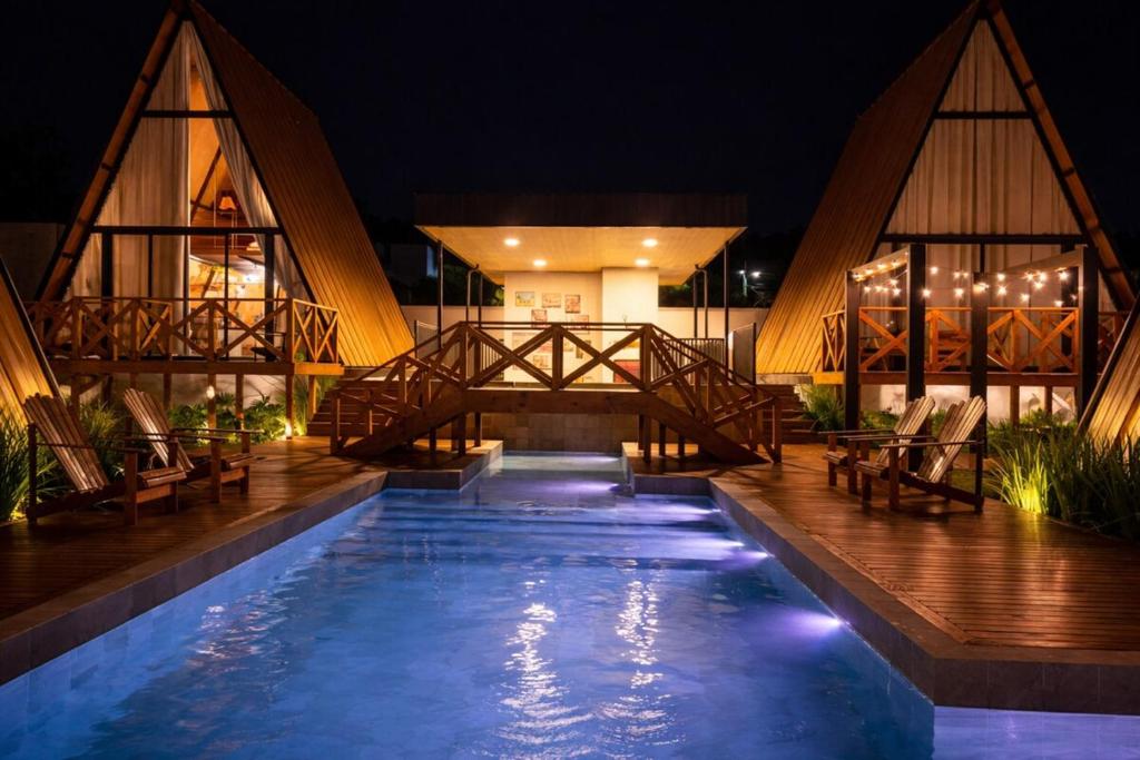 a swimming pool in front of a building at night at Cabana Industrial in Palhoça