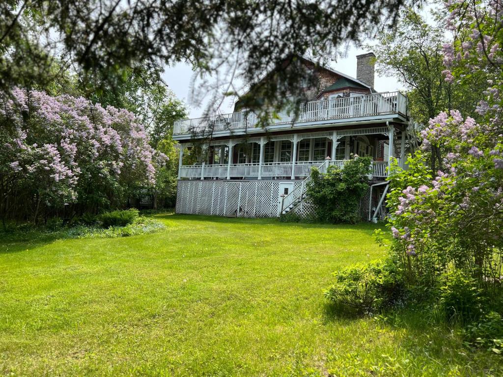 a large house with a yard with flowers at Auberge la Romance in La Malbaie