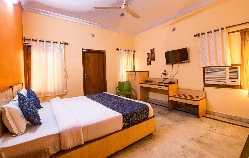 a bedroom with a bed and a desk with a computer at Greenland Premium Hotel in Bhubaneshwar