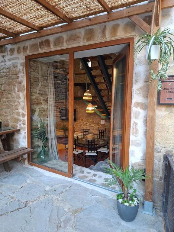 a stone house with a patio with a dining room at Casa Rural Arco Navarra in Artariáin