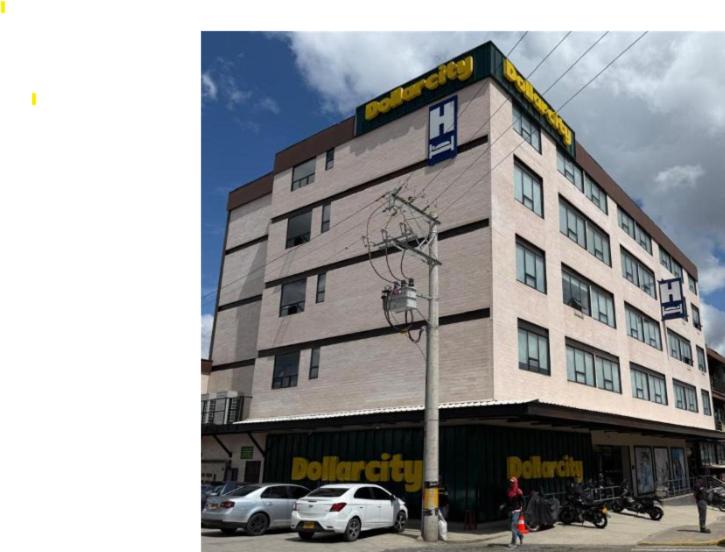 a large building with cars parked in front of it at Hotel LaRamada in Marinilla