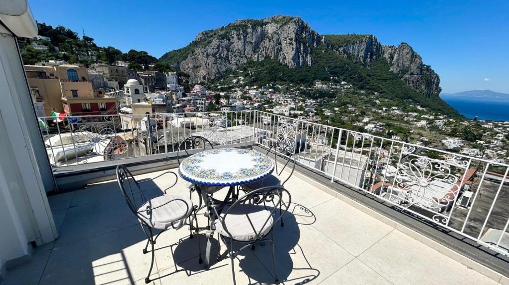 a table and chairs on a balcony with a view at Rooftop luxury apartment in Capri