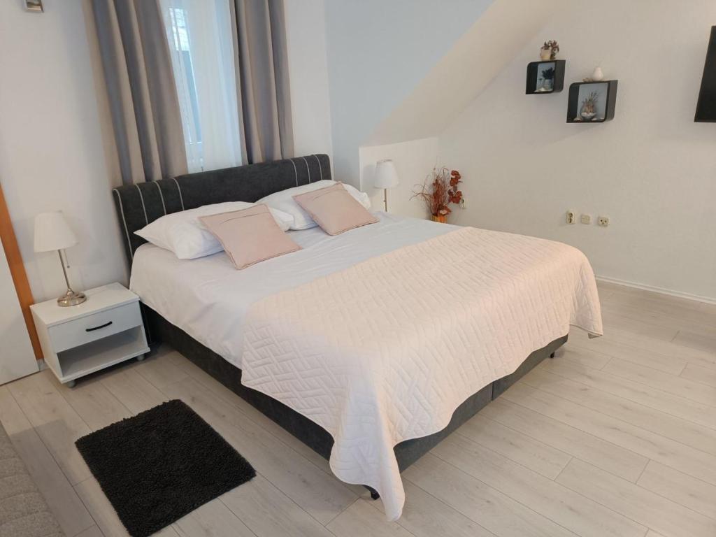 sypialnia z dużym łóżkiem i różowymi poduszkami w obiekcie Studio Banovac w Dubrowniku