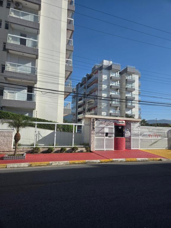 an empty street in front of a building with a red door at terraços do maitinga in Bertioga