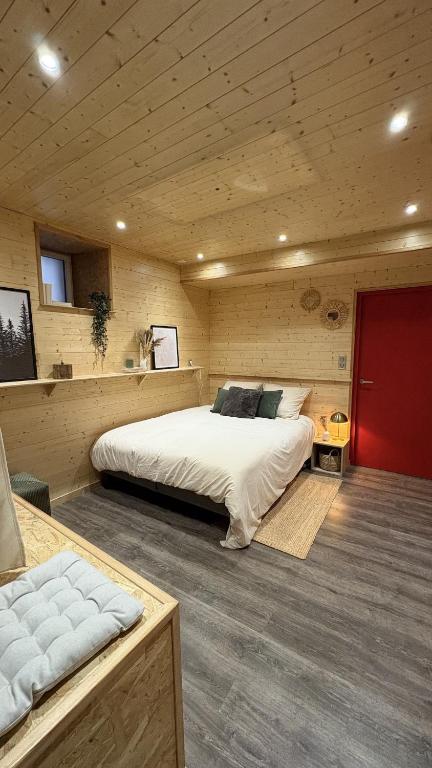 a bedroom with two beds in a wooden room at Le petit chalet de Cholet in Cholet