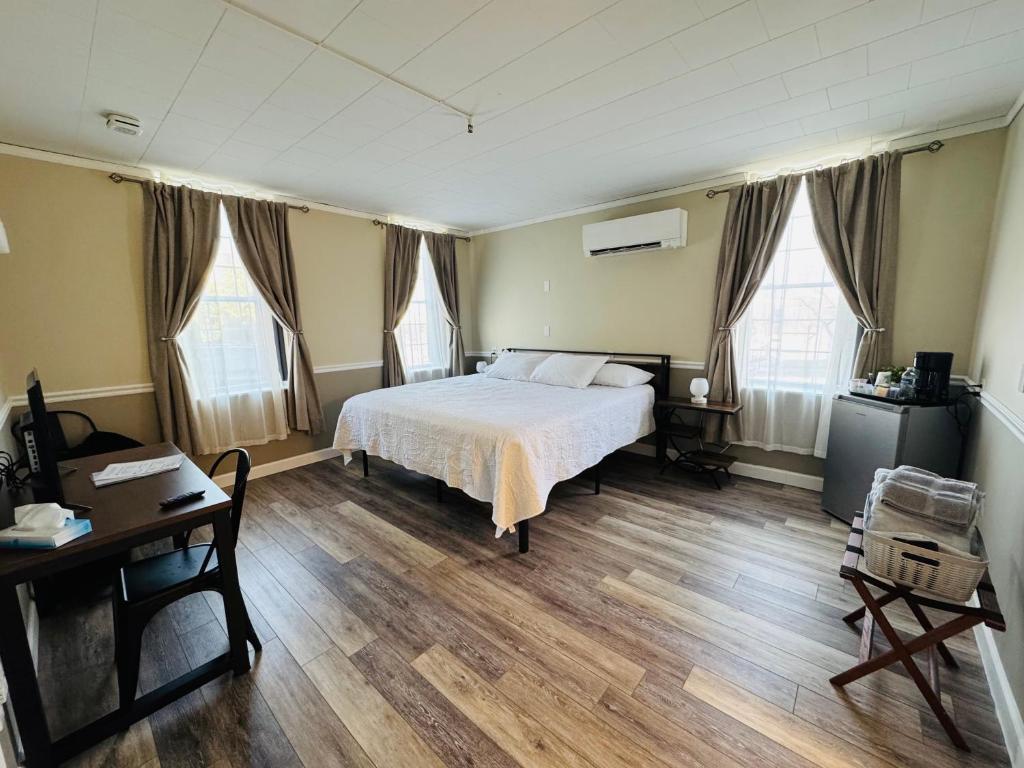 a bedroom with a bed and a desk and windows at Nestle Inn in Hermann