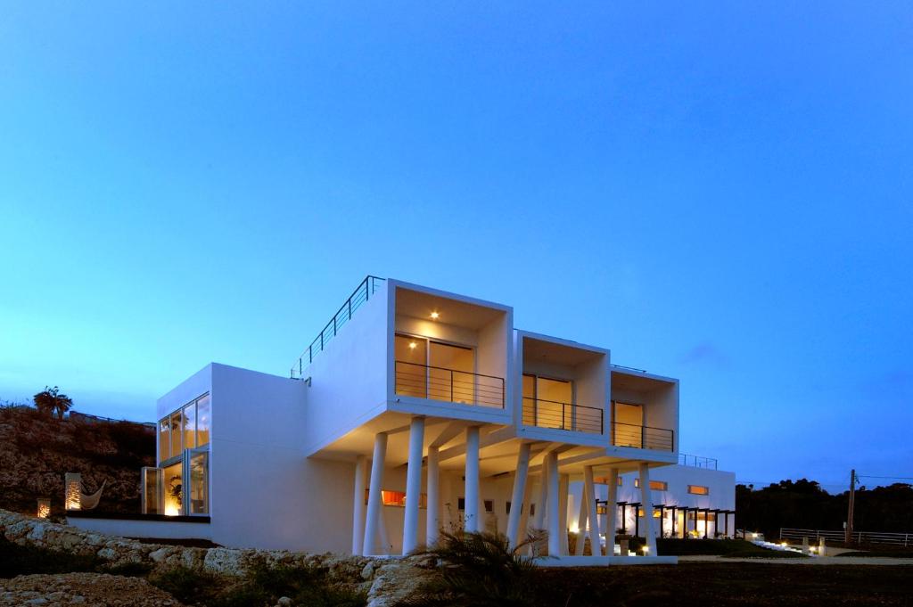 a white building with a blue sky at Private Resort Hotel RENN in Miyako Island