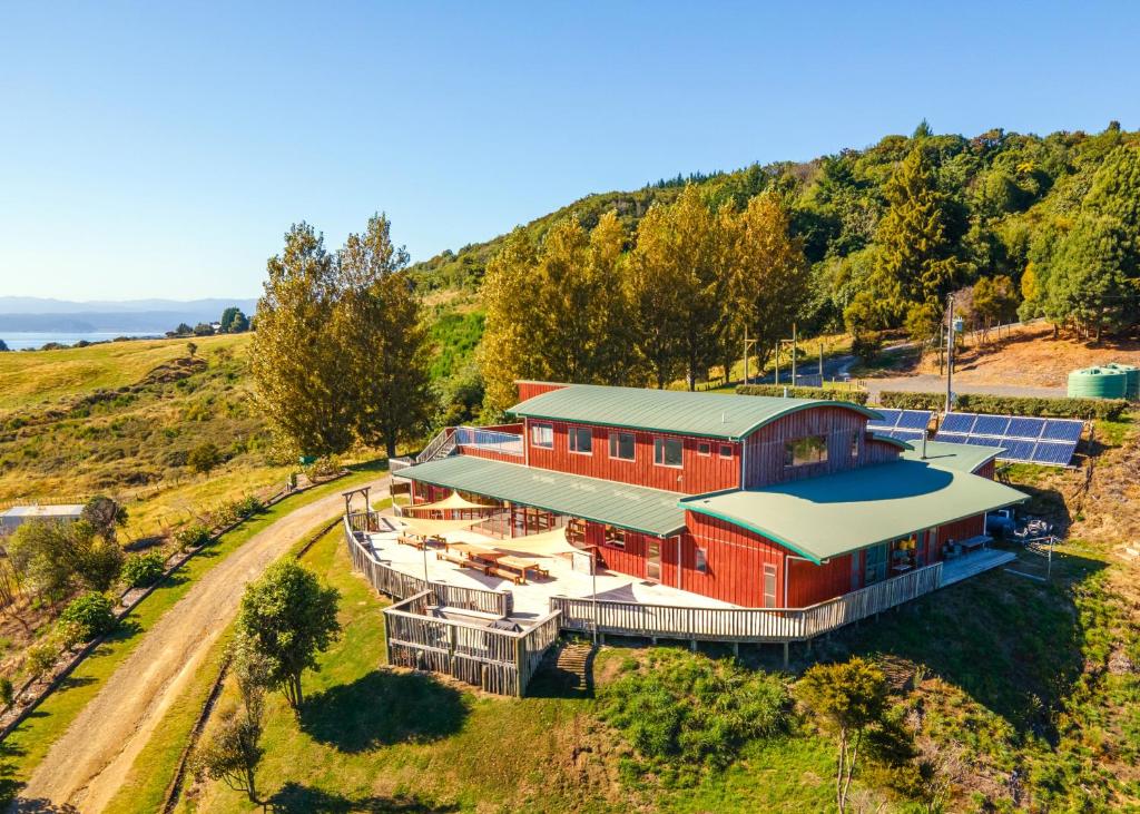 an aerial view of a red house on a hill at Omori Lodge in Tokaanu