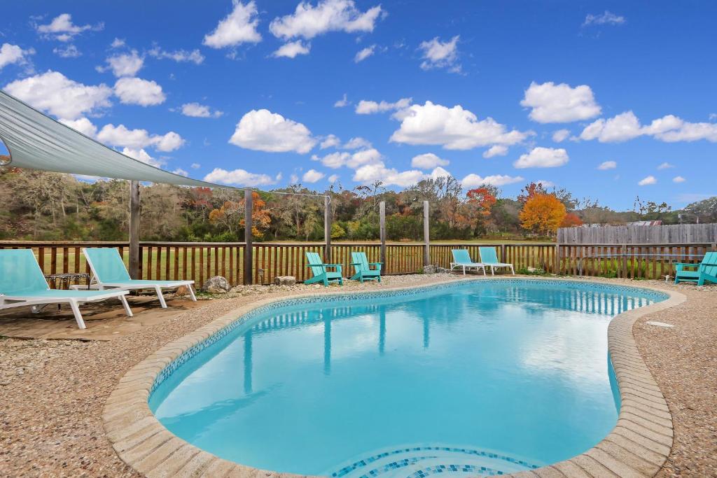 a swimming pool with chairs and a fence at Arrowhead Falls in Wimberley