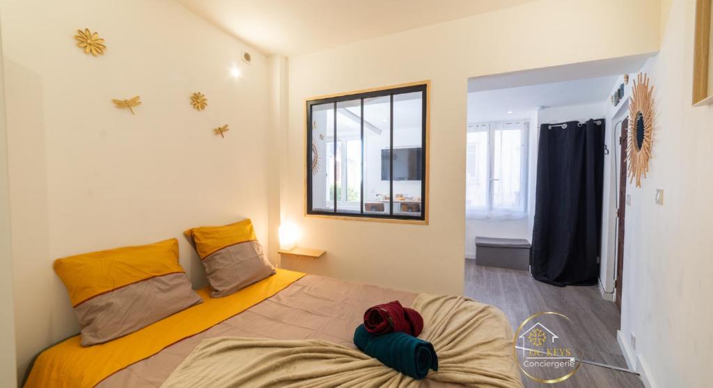 a bedroom with a bed and a mirror and a window at Escapade studio centre ville Rodez in Rodez
