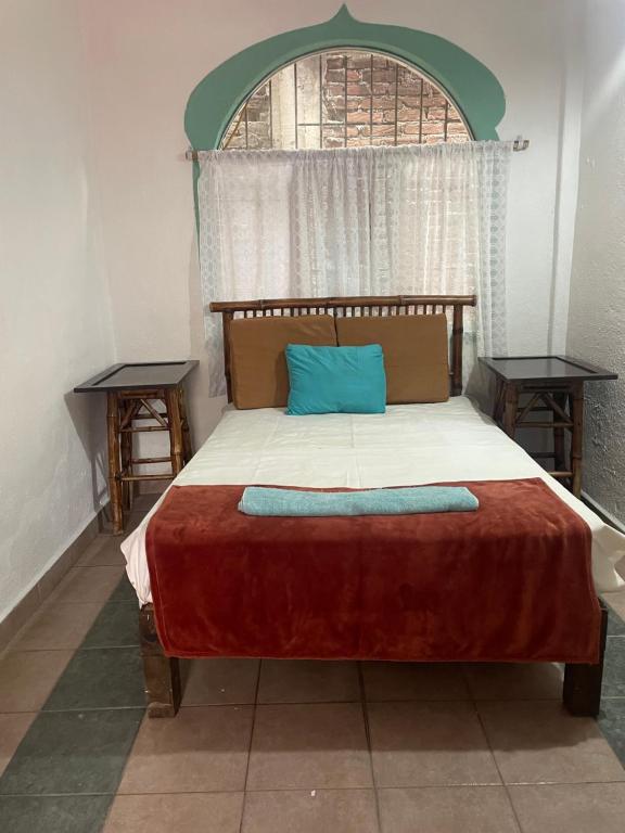 a bedroom with a bed with a blue pillow on it at Casa Malinalli in Zihuatanejo