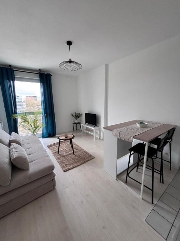 a living room with a couch and a table at Studio cosy - Proche centre Dijon in Dijon