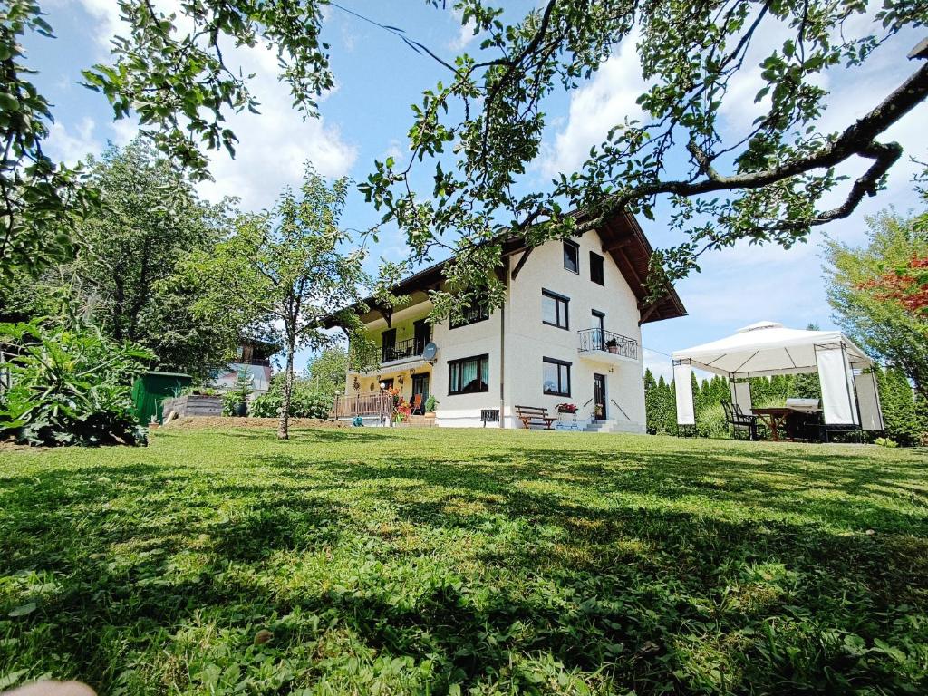 a large white house with a grass yard at Große Ferienwohnung im Rosental ideal für 4 bis 6 Personen mit Balkon und Garten in Maria Elend