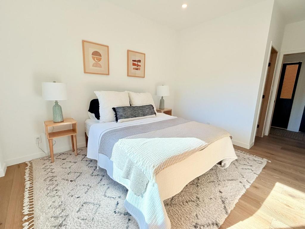 a white bedroom with a bed and a rug at Private Hillside 2BR Suite Near Town in Ojai