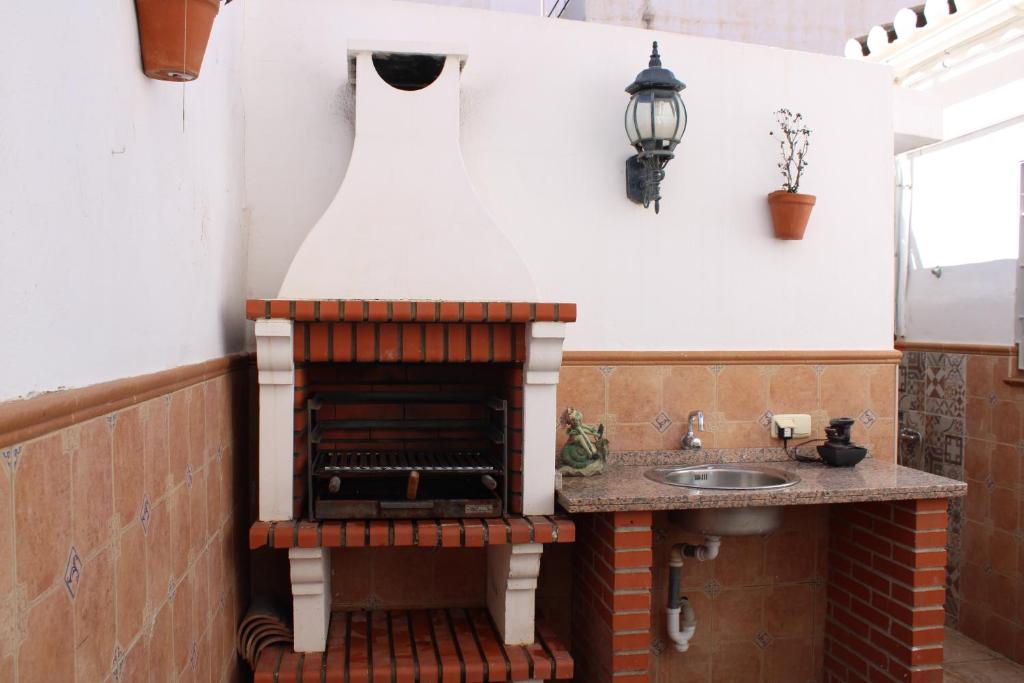 a kitchen with a brick oven and a sink at Casa Calera in Nerja