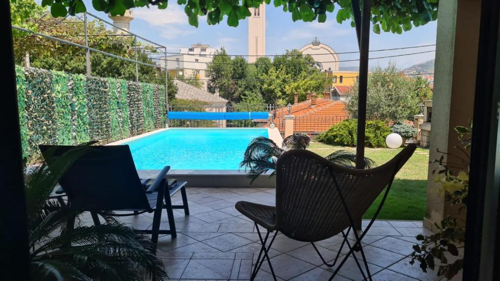 a patio with two chairs and a swimming pool at Apartman Karla in Mostar