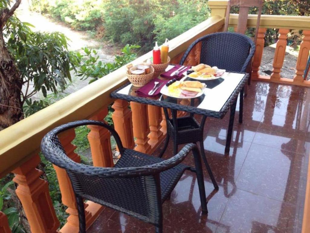 einen Tisch mit Tellern aus Essen auf einem Balkon in der Unterkunft Apsara Guest House Kampot City in Kampot