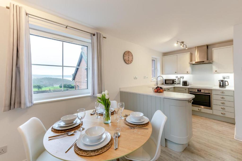 a kitchen with a table with chairs and a dining room at 2 Bed in Woolacombe oc-bsnug in Woolacombe