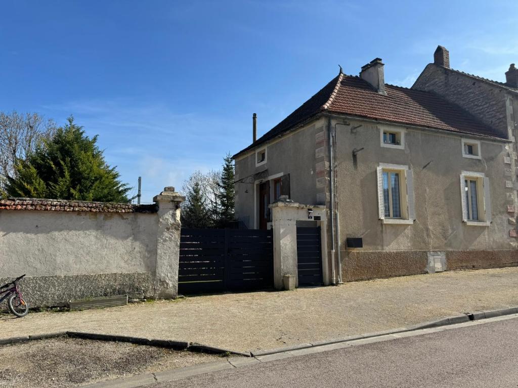 an old house with a gate in front of it at Gite la fontaine dargent in Aisy-sur-Armançon