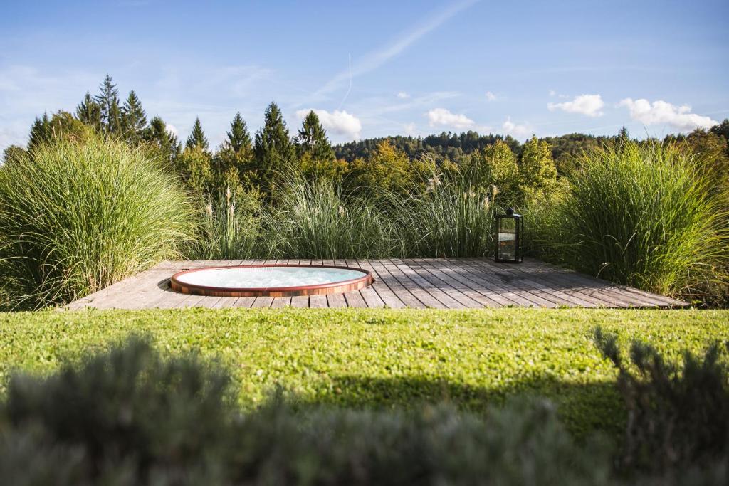 a wooden deck with a fire pit in a garden at Lill' Hill estate & wellness - Anna Apartment in Idrija