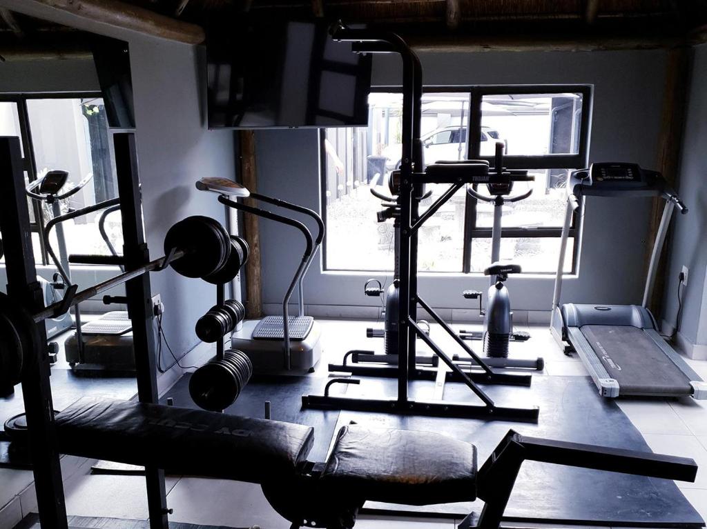a gym with several exercise bikes and a mirror at Haleys Guest House in Benoni