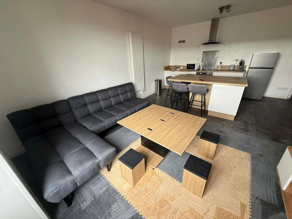 a living room with a couch and a table at Appart' Val 2 in Beaumont