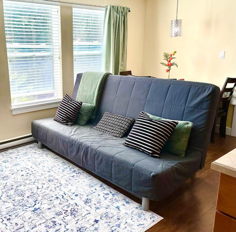 a blue couch in a living room with pillows at Sunny 1BR by Galloping Goose in Victoria