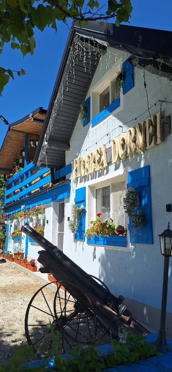 a building with a sign on the side of it at Pensiunea Floarea Dornei in Şarul Dornei