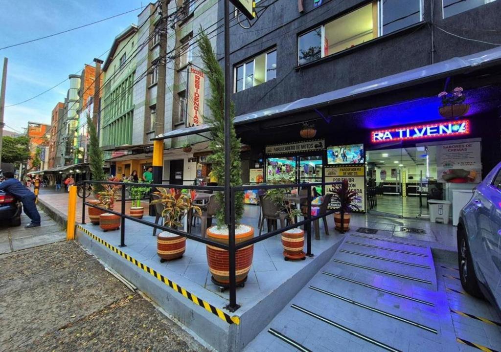 a restaurant with potted plants on a city street at Hotel Playa Itagui in Itagüí