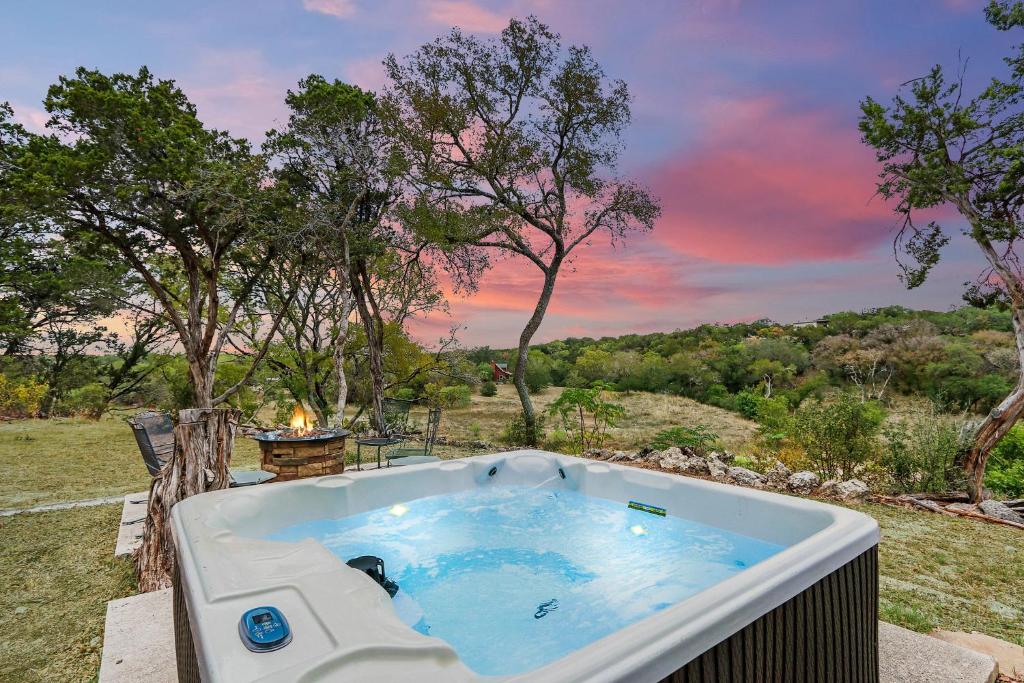 a jacuzzi tub with a sunset in a field at Bungalow on the Bluff in Fischer