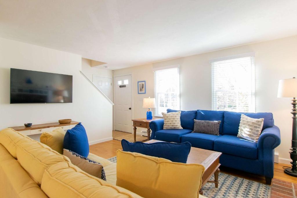 a living room with a blue couch and chairs at Spacious w Beautiful Yard & Dogs Welcome in Harwich