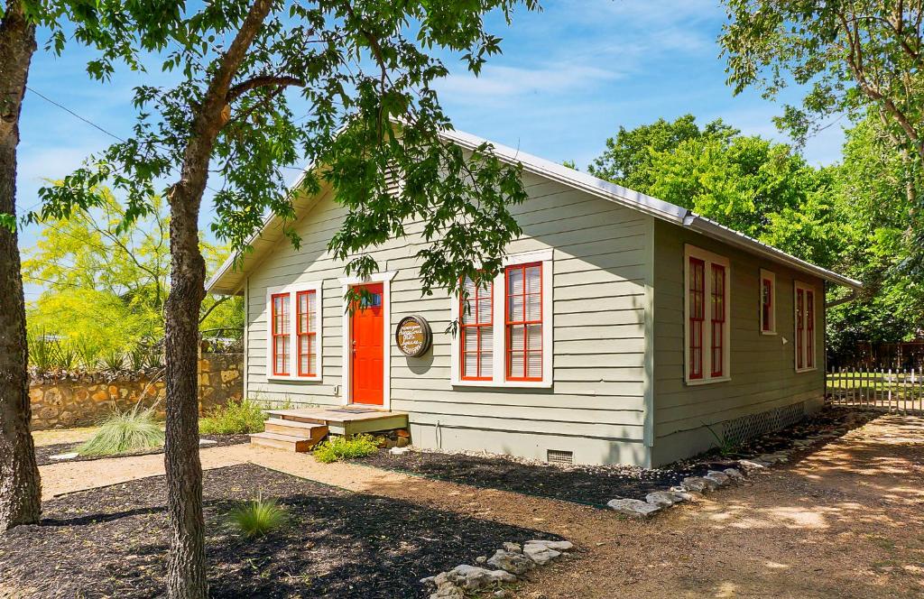 a small white house with an orange door at Bungalows on the Square- Unit 1 in Wimberley