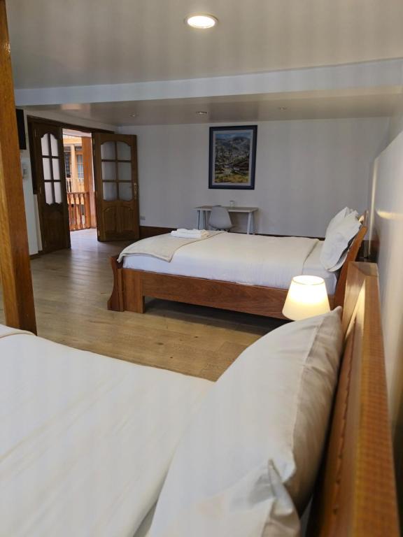 a hotel room with two beds and a table at Hotel Aural in Cajamarca