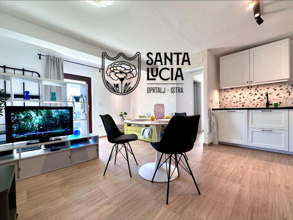 a kitchen with a table and chairs in a room at Santa Lucia App in Oprtalj