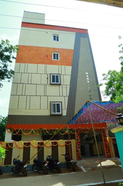 a building with motorcycles parked in front of it at hotel Mansion grand in Khammam