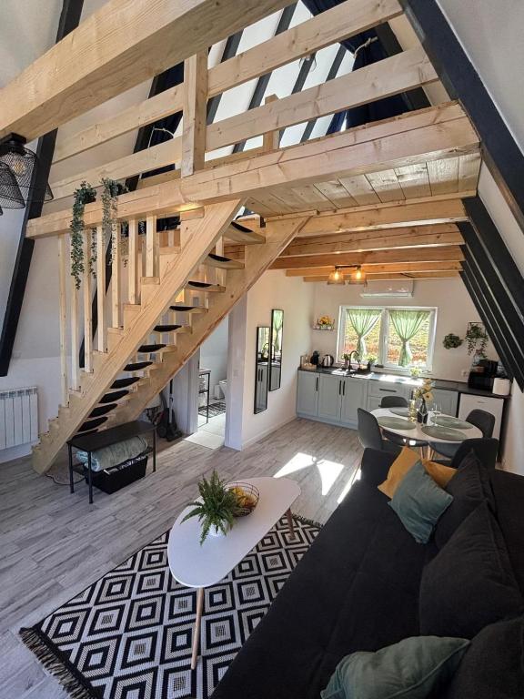 a living room with a couch and a staircase at NOOR A-frame Sibiu in Gura Râului