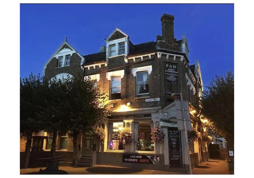 a large brick building on a street at night at Forest Gate Hotel - Free Parking limited spaces in London