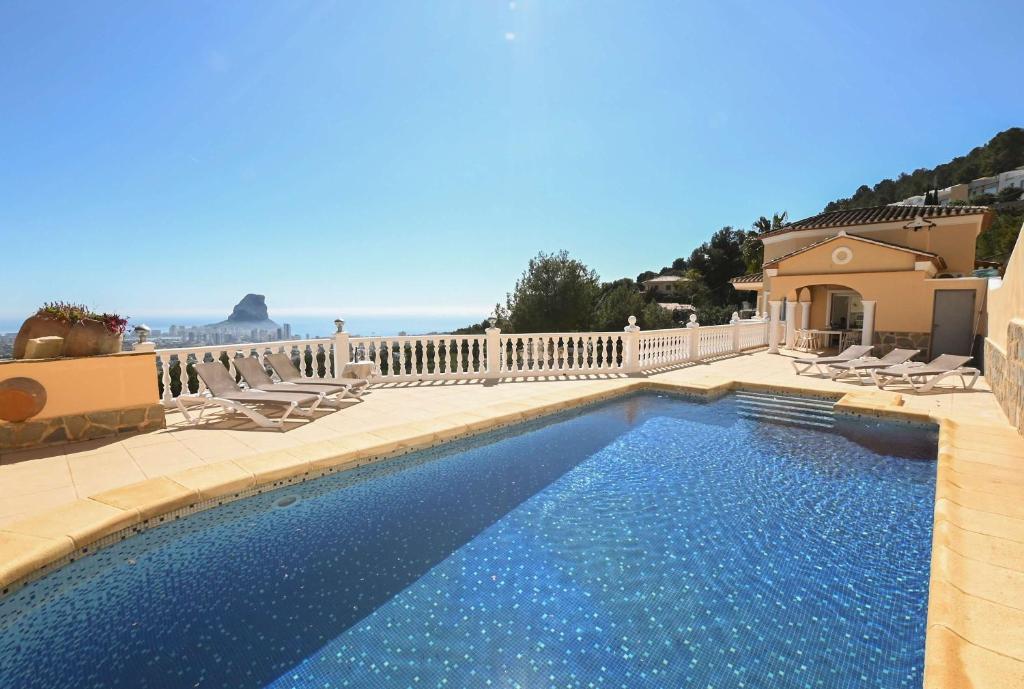a swimming pool with chairs and a house at Luxury Sea View Villa Oltamar - Single Level - Private Pool - Full Privacy in Calpe