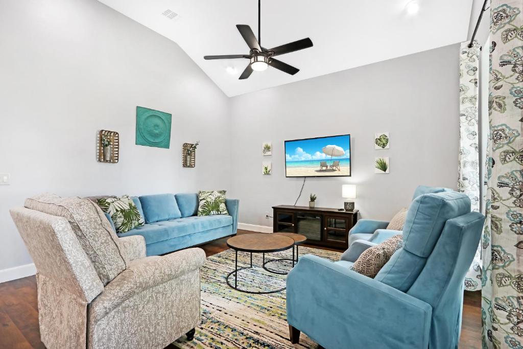 a living room with blue furniture and a ceiling fan at Comal Cottage in Canyon Lake