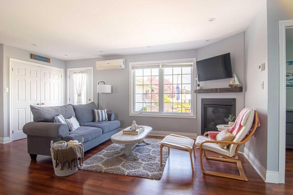 a living room with a blue couch and a fireplace at Apartment in Prince Edward County - 'Suite Spot' in Picton