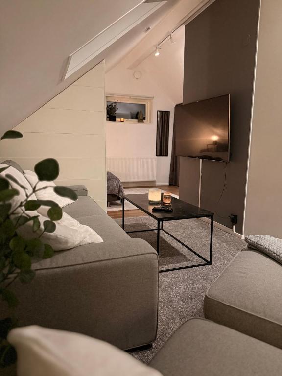 a living room with a couch and a table at Cozy apartment in Kungsbacka