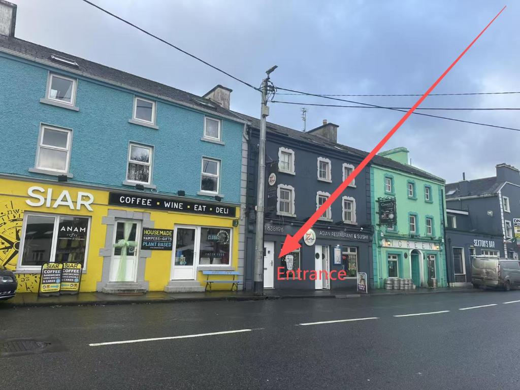 a red arrow on a city street with buildings at Cove Guest Accommodation in Kinvara
