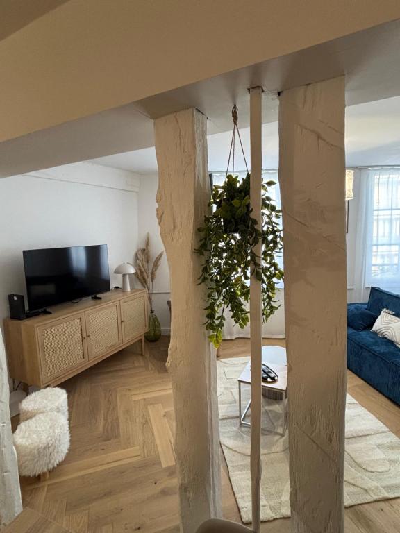 a living room with a blue couch and a tv at La Parenthèse in Chalons en Champagne