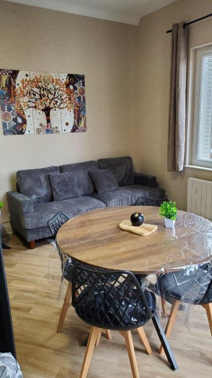 a living room with a table and a couch at Charmant T2 Spacieux idéalement situé - 2 chambres in Clermont-Ferrand